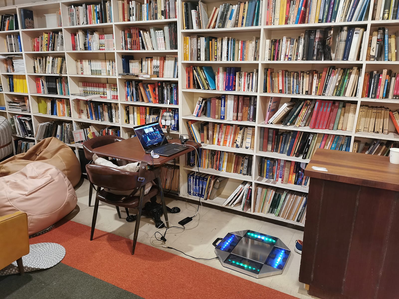 My mini pad set up beside the upper floor’s bookshelf, in front of a table around the same height as the bar.